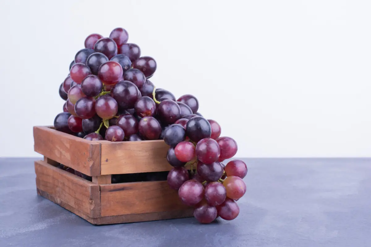 A bunch of grapes in a wooden tray, A bunch of grapes in a wooden tray. High quality photo