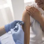 doctora la coloca la vacuna a una joven