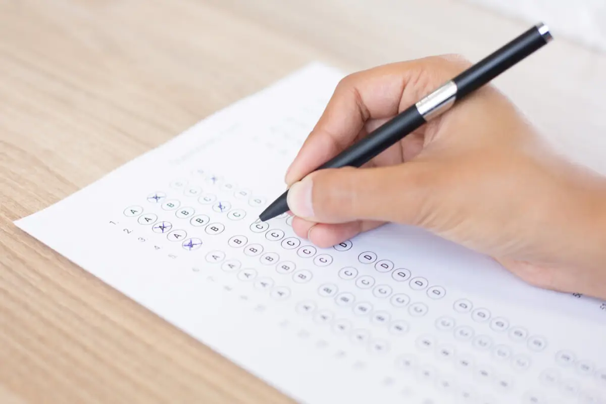 Closeup of Person Filling out Questionary Form, Closeup of hand holding pen and filling out questionary form on table