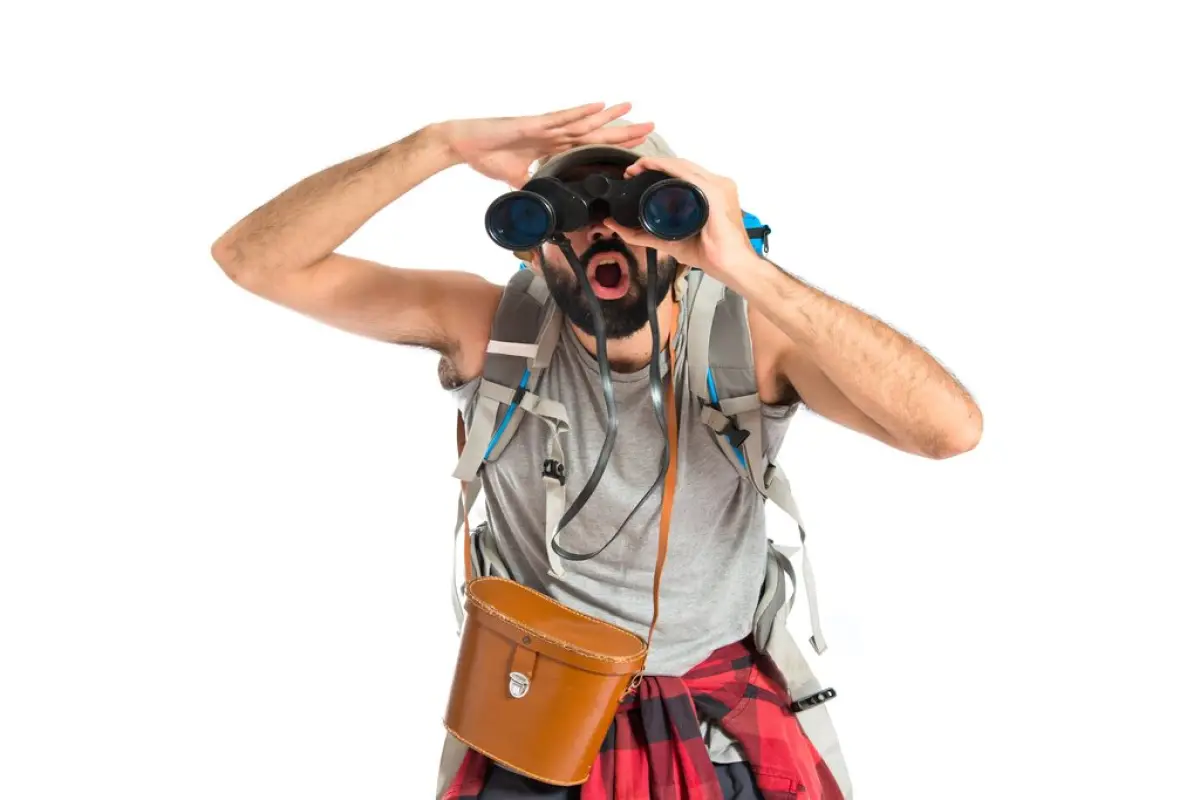 Backpacker with binoculars over isolated white background,  