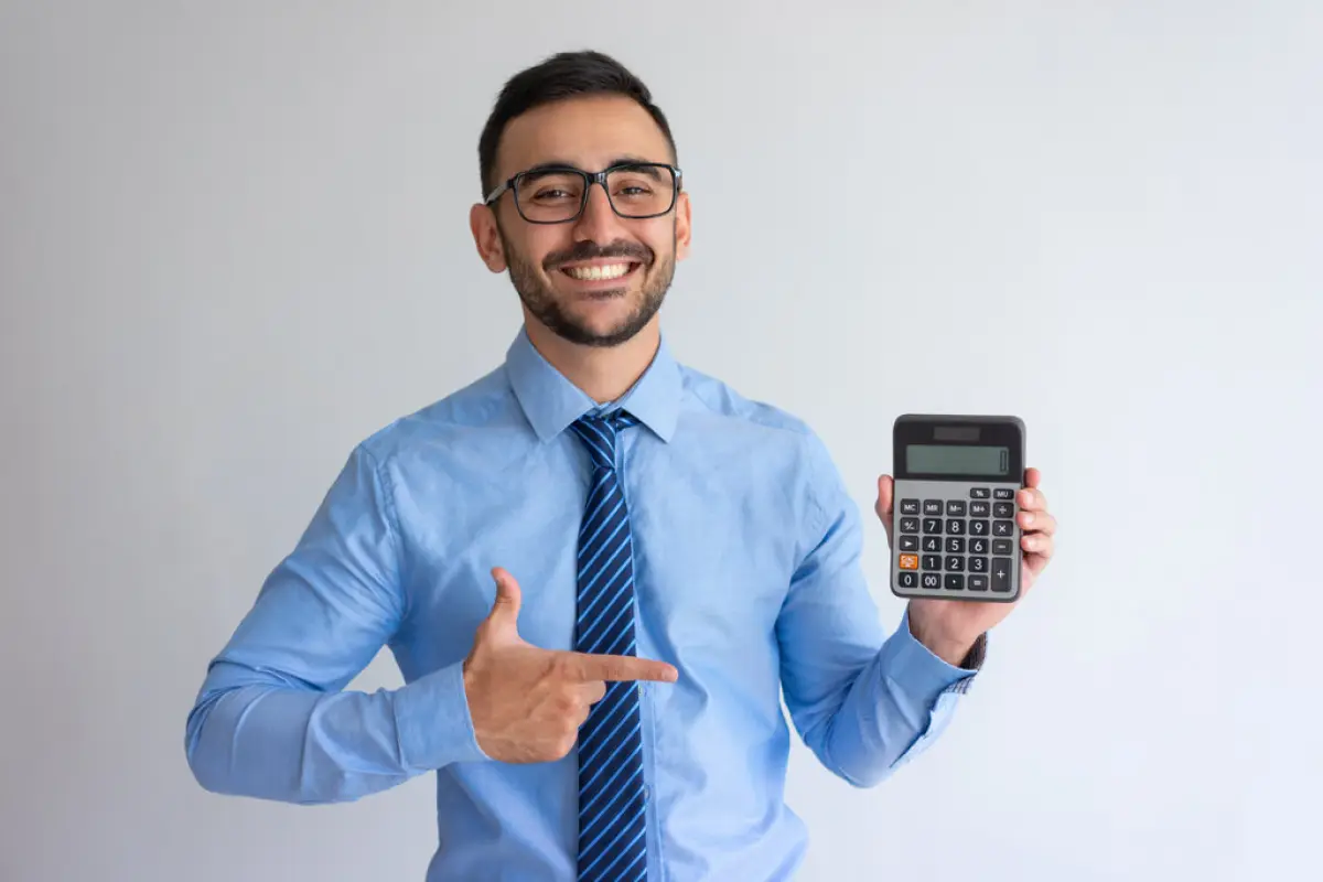 Cheerful banker advertising loan program, Cheerful banker advertising loan program. Content young man in glasses and tie pointing at calculator. Finance or banking concept