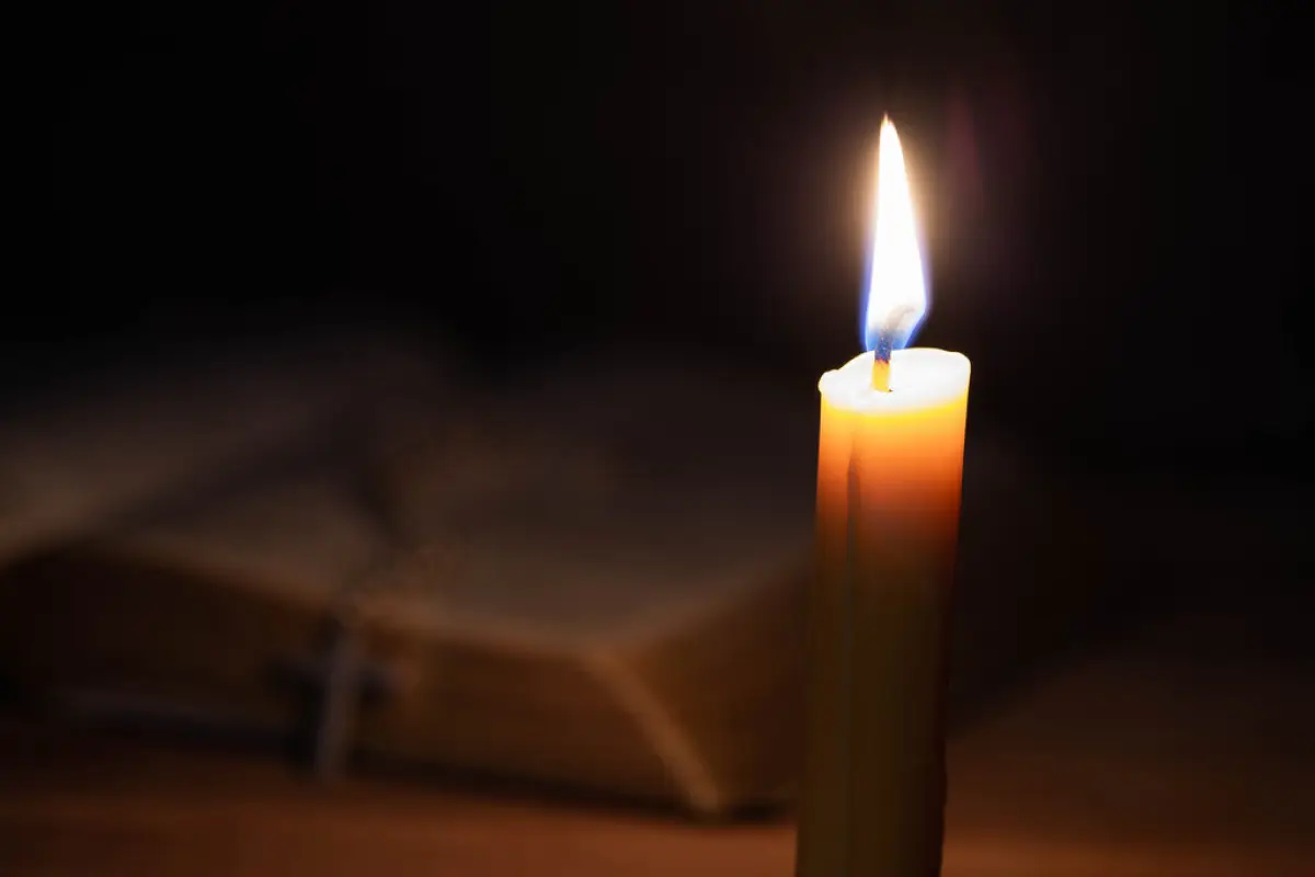 una vela iluminando una biblia