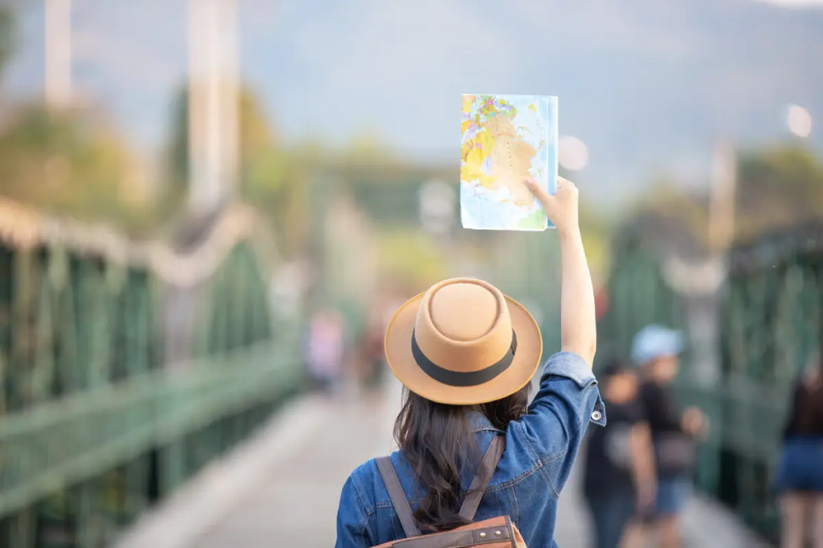 Female tourists on hand have a happy travel map.,  