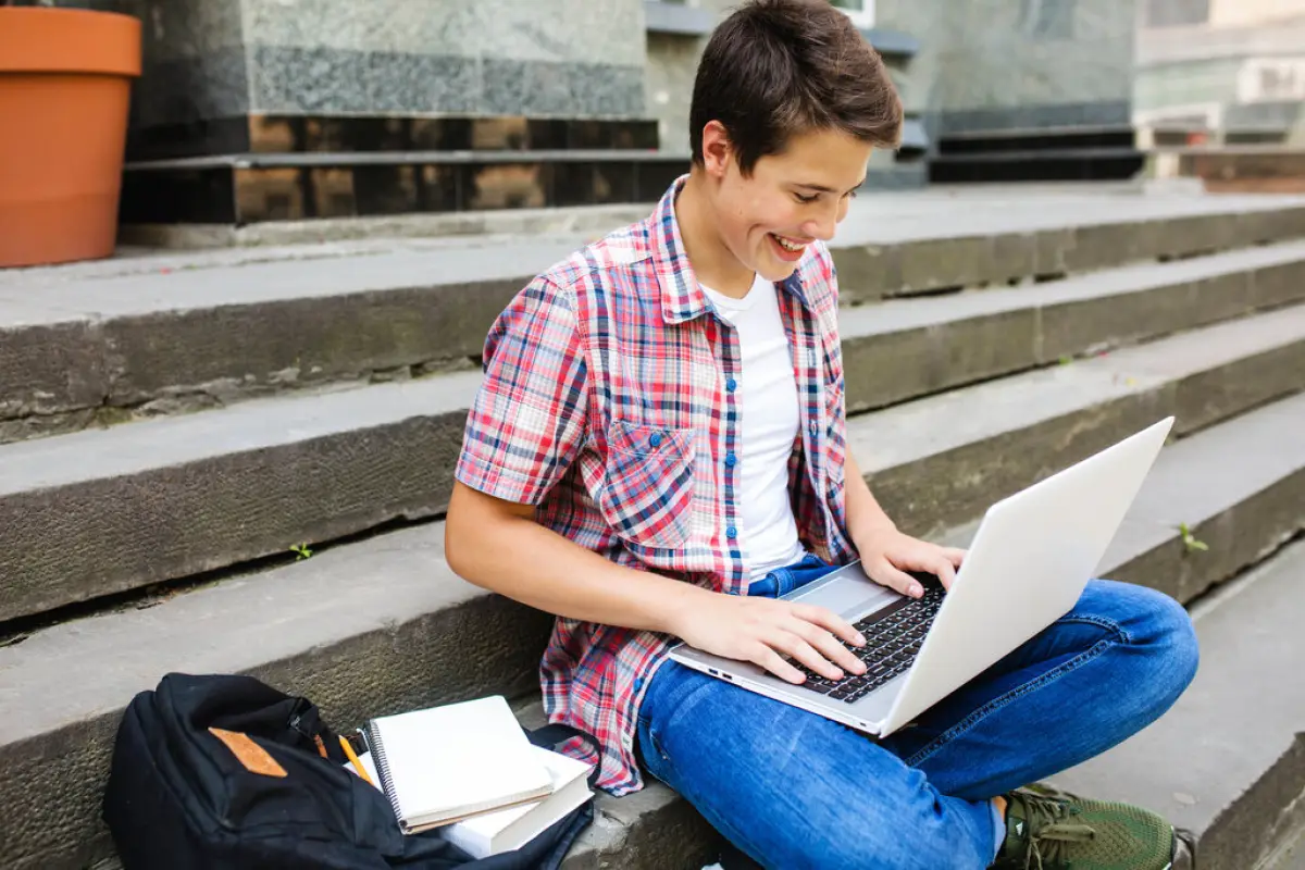 joven estudiante sonriente mirando su laptop