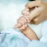 Newborn baby holding hands mom,  