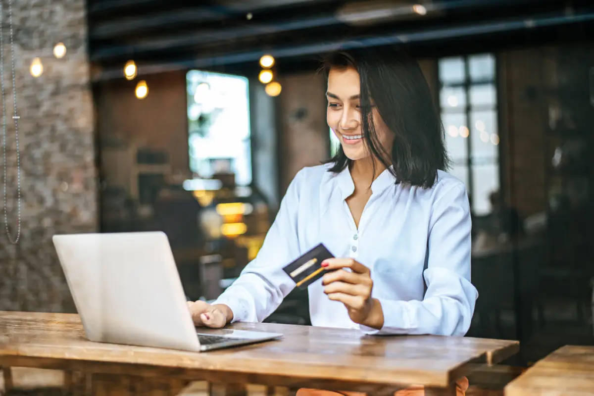 mujer con tarjeta de crédito y laptop