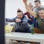 hombres viendo fútbol en el televisor