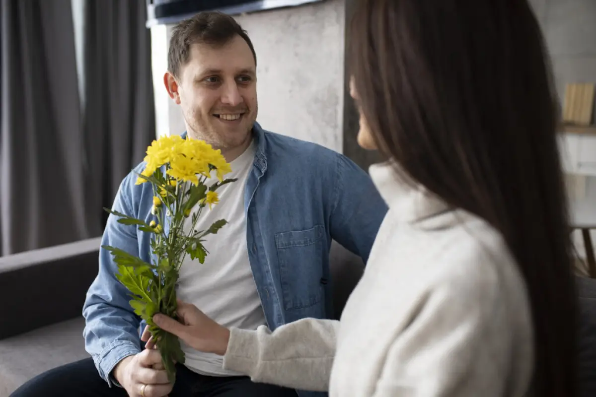 hombre entregando flores amarillas a su pareja