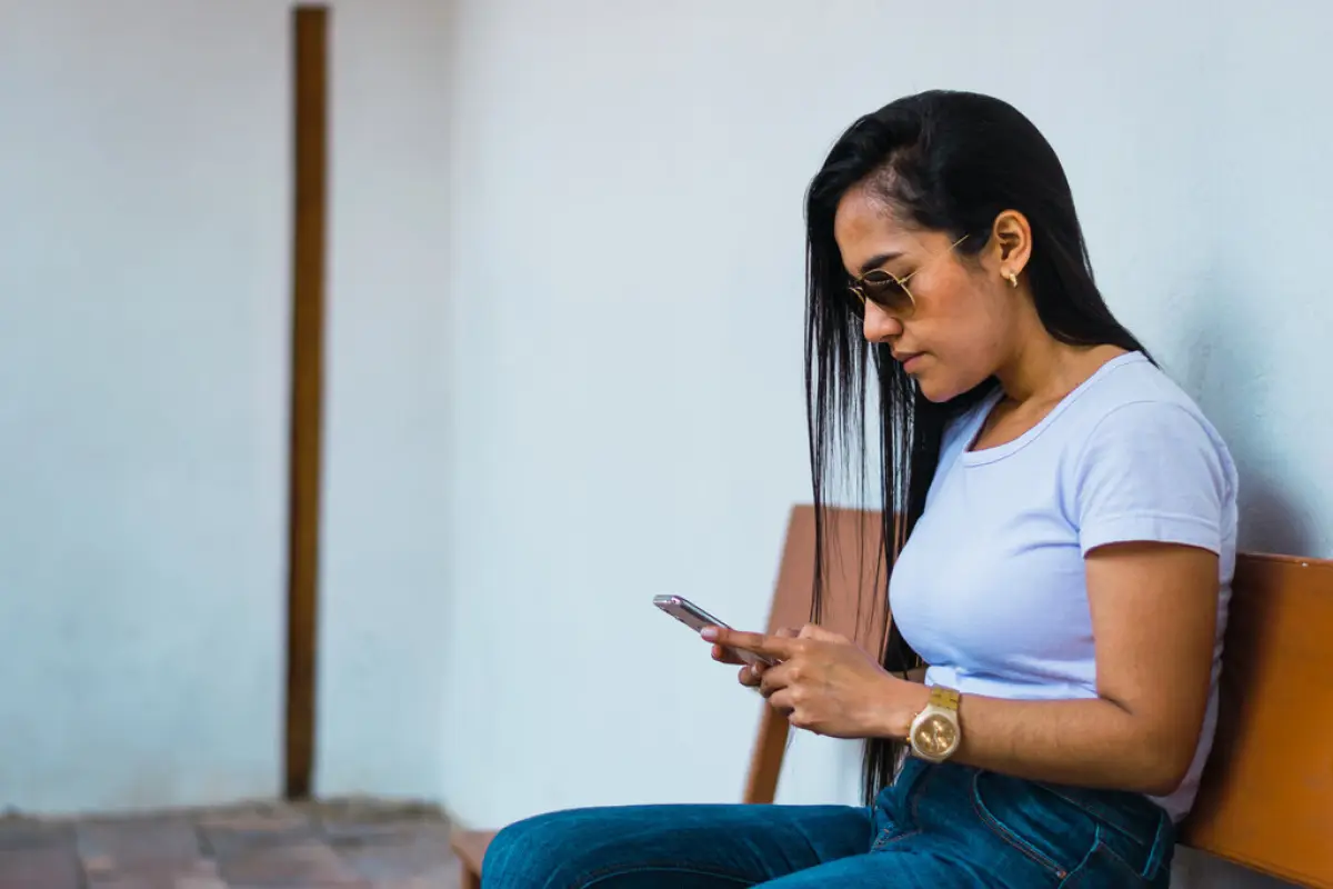 joven colombiana viendo su celular